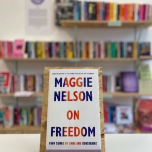 English: A copy of 'On Freedom' sits on a stand in front of multiple shelves of other books.