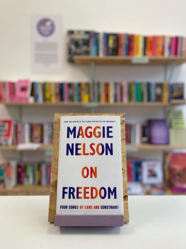 English: A copy of 'On Freedom' sits on a stand in front of multiple shelves of other books.