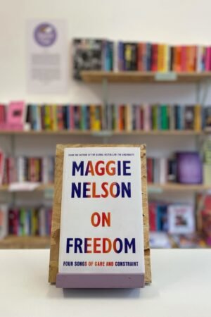 English: A copy of 'On Freedom' sits on a stand in front of multiple shelves of other books.