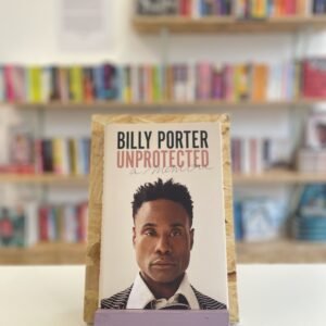 A copy of 'Unprotected' sits on a stand in front of multiple shelves of other books.