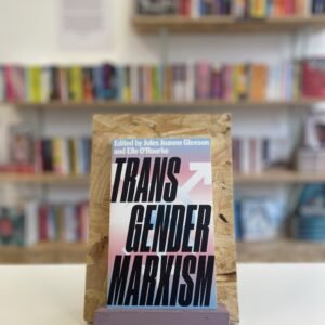 Cymraeg: Copi o 'Transgender Marxism' yn sefyll ar stondin llyfrau, tu blaen silffoedd o lyfrau yn y cefndir. English: A copy of 'Transgender Marxism' sits on a stand in front of multiple shelves of other books.