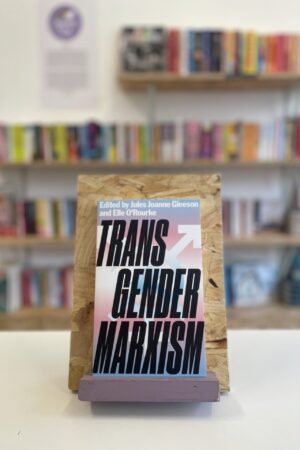 Cymraeg: Copi o 'Transgender Marxism' yn sefyll ar stondin llyfrau, tu blaen silffoedd o lyfrau yn y cefndir. English: A copy of 'Transgender Marxism' sits on a stand in front of multiple shelves of other books.