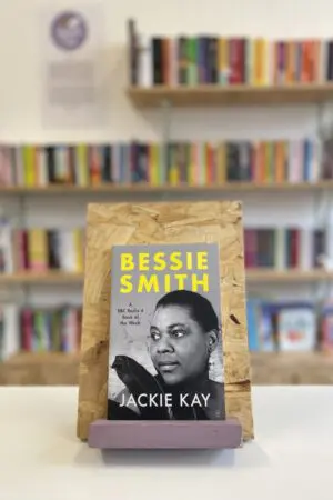 A copy of 'Bessie Smith' sits on a stand in front of multiple shelves of other books.