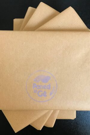 A pile of brown, square parcels on a black surface, asymmetrically arranged. Paned o Gê's logo is printed in lavender on the top parcel.