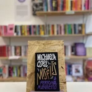 A copy of 'Misfits' sits on a stand in front of multiple shelves of other books.