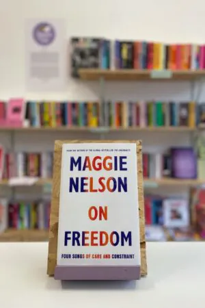 English: A copy of 'On Freedom' sits on a stand in front of multiple shelves of other books.